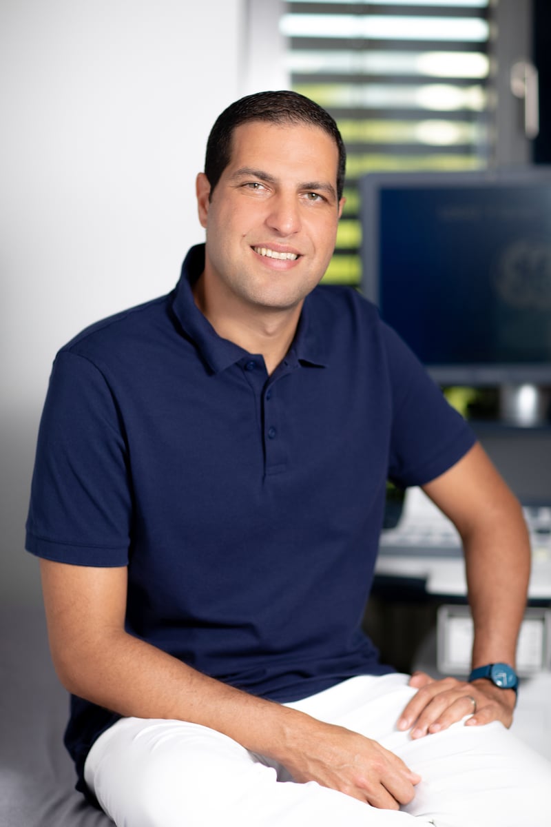 Dr. Amro Homssi, Facharzt für Orthopädie und Unfallchirurgie in Berlin, sitzend vor einem Monitor