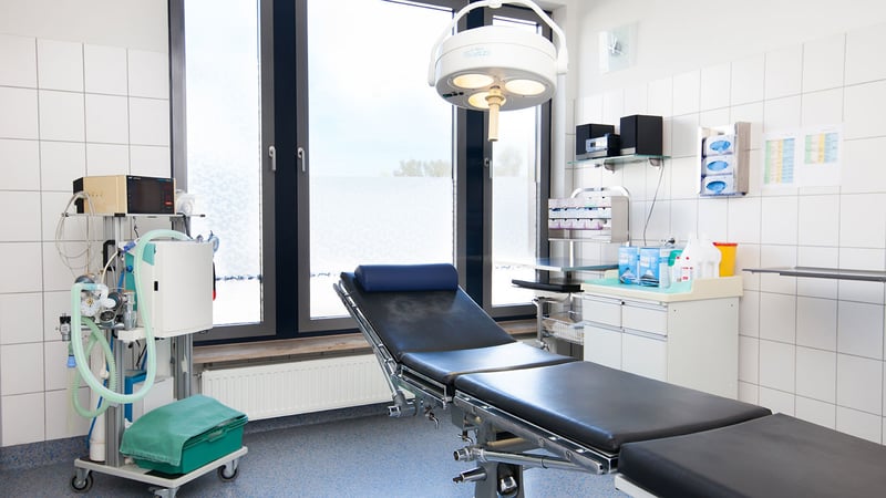 Eingriffsraum der Praxis Dr. Homssi in Berlin mit OP-Liege und OP-Leuchte für die Laserbehandlung eingewachsener Zehennägel