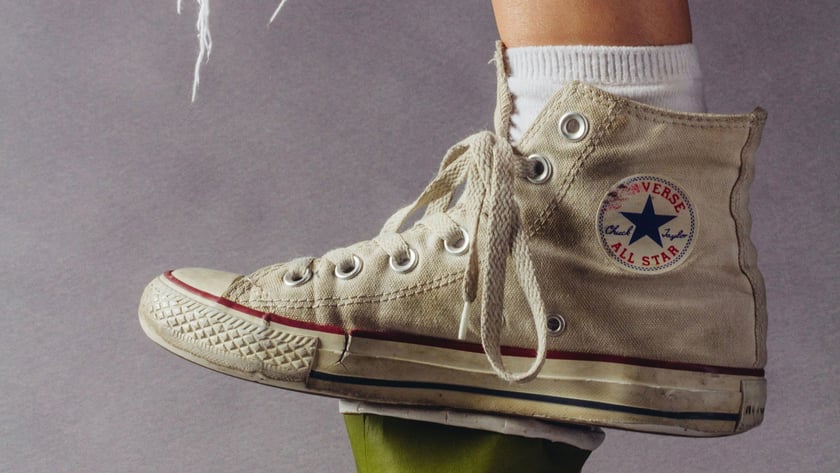 Heller, knöchelhoher Stoff-Sneaker mit weißer Socke, schlecht belüftete Schuhe begünstigen Fußpilz